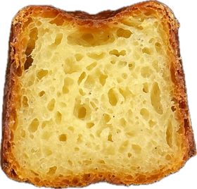 A canelé cut in half showing its custardy honeycomb interior