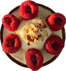 An almond raspberry tart topped with cream, sliced almonds and a ring of raspberries, seen from above